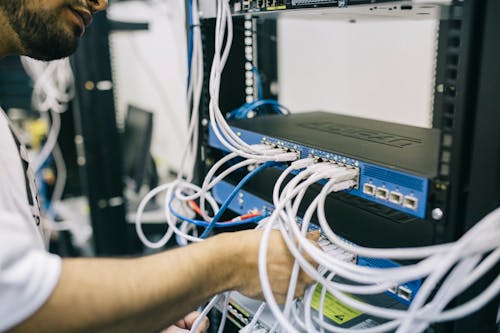 Technician working with network cables in a server rack