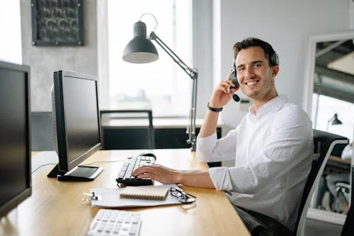 Support representative at a desk using a headset